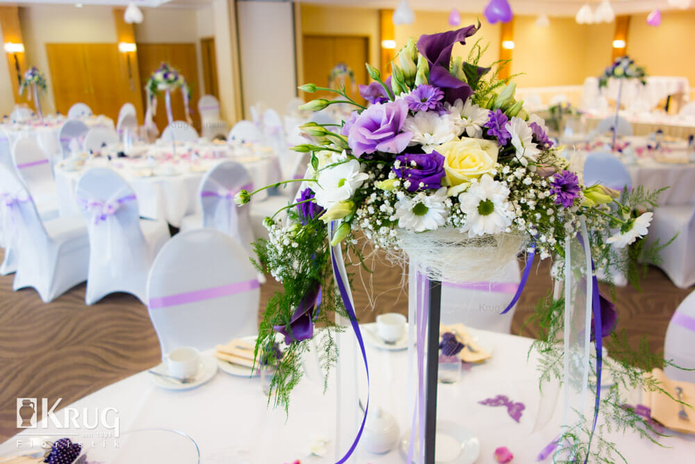 hohe Tisch-Dekoration zur Hochzeit in lila-weiß