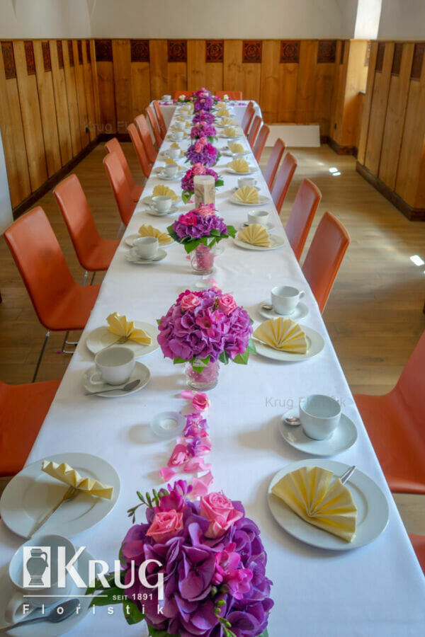 Hochzeits-Tafel mit lila-pinken Blumen in Vase