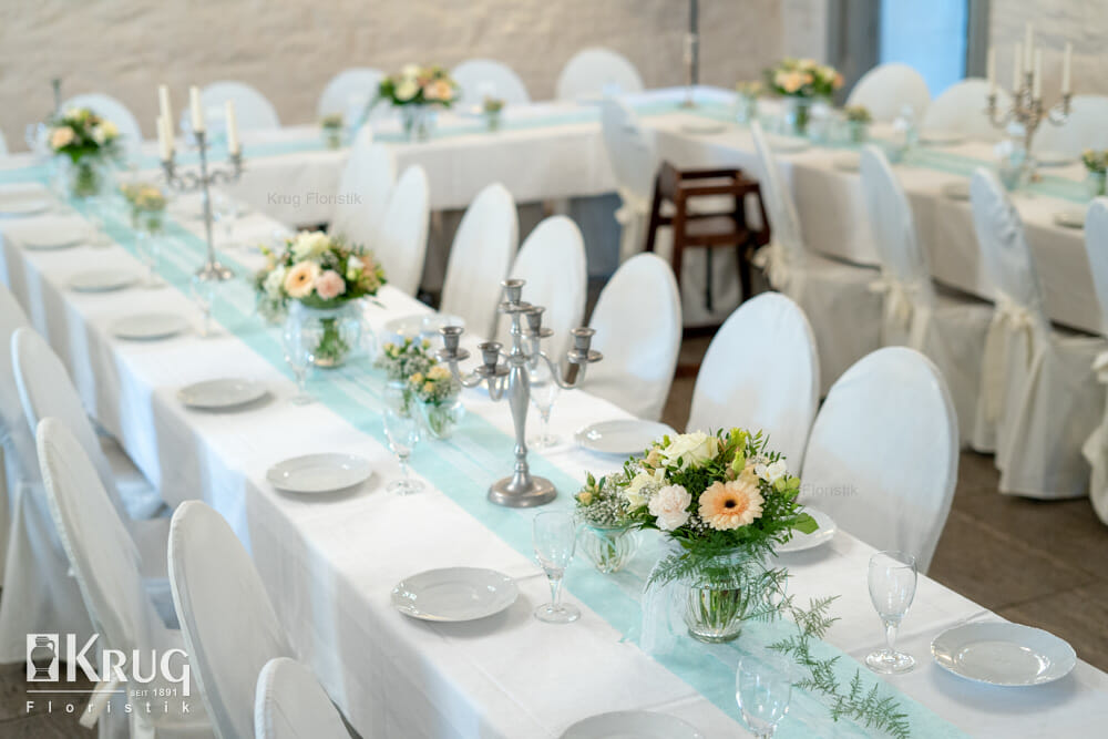 creme-farbene Blumen auf türkisem Hochzeits-Tisch