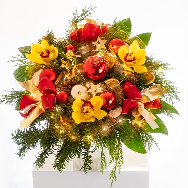 riesiger Blumenstrauß mit Lichterkette, roten Kugeln und gelben Orchideen Blüten