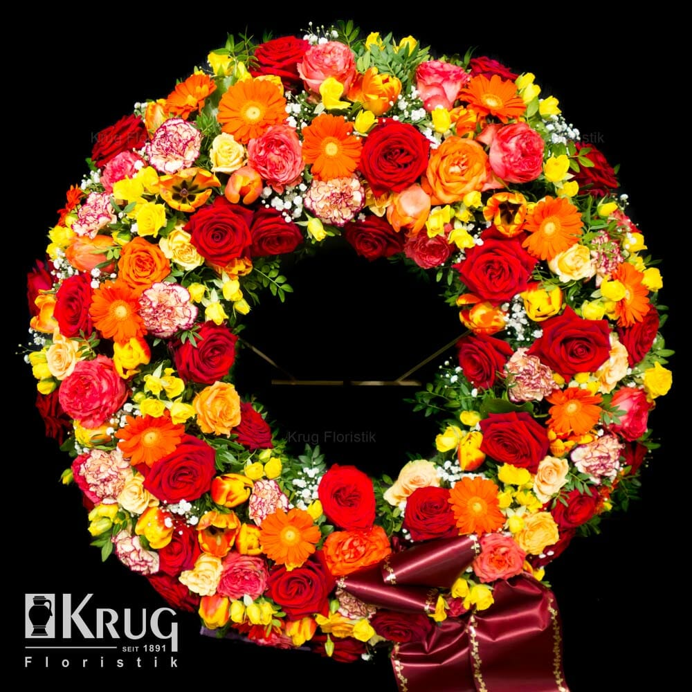 Blumen-Kranz zur Bestattung mit roten und gelben Rosen, Freesien, orangenen Gerbera, Tulpen, Nelken